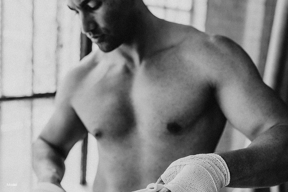 Fit man wrapping his hands in hands wraps