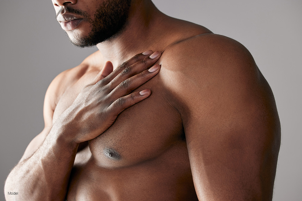 Fit man with his hand on his chest